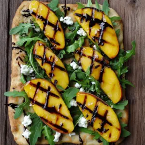 - Flatbread options: You can choose store-bought or make your own. Store-bought is quick and easy. Homemade flatbread offers a fun, hands-on experience. Both options work well. - Importance of ripe peaches: Ripe peaches bring sweetness and juice. They add great flavor to your flatbread. Look for peaches that yield slightly when pressed. This means they are ready to eat. - Flavorful additions: Goat cheese and balsamic glaze add depth. Goat cheese is creamy and tangy, which complements the sweet peaches. Balsamic glaze adds a perfect balance of sweetness and acidity. It elevates the dish and makes it even more delightful. Using these ingredients, you will create a grilled peach and arugula flatbread that bursts with flavor. For the complete steps, check the Full Recipe. Start by slicing the ripe peaches. Toss them in a bowl with olive oil, salt, and pepper. This mix will enhance their flavor. Aim for about 1 tablespoon of olive oil per two peaches. Preheat your grill to medium-high heat. The perfect temperature is around 400°F. Grill the peach slices for 2-3 minutes on each side. You want them tender with nice grill marks. Next, prepare the flatbreads. Brush each side with olive oil. This step helps achieve that delicious crispy texture. Place the flatbreads on the grill. Grill for about 2-3 minutes. Watch closely for those beautiful grill marks to form. Flip them over and grill for another minute if needed. Now comes the fun part—assembly! Start by laying the grilled peaches on the flatbread. Spread them out evenly. Next, add a generous handful of fresh arugula. Crumble goat cheese on top for a creamy touch. Finally, drizzle balsamic glaze over the entire flatbread. Adjust the amount to suit your taste. If you like, add fresh basil leaves for an extra pop of flavor. Slice and enjoy your grilled peach and arugula flatbread! For the complete cooking details, check the Full Recipe. To get perfect grill marks, preheat your grill well. Aim for medium-high heat. Place the flatbread on the grill for about two to three minutes. Watch closely to see those lovely marks form. Flip it once, and you'll have a beautiful pattern. To avoid sticky peaches, choose ripe but firm ones. Toss them with a bit of olive oil before grilling. This small step helps keep them from sticking to the grill. Grill them for two to three minutes on each side. You want them charred and soft but not mushy. When it comes to cheese, goat cheese is a favorite. If you want a milder taste, try feta cheese. For a creamier option, use ricotta or burrata. Each cheese adds a unique twist to your flatbread. For greens, arugula is great, but you can switch things up. Try fresh spinach for a mild flavor. You can also use basil or mint for extra freshness. These changes give you many ways to enjoy your flatbread. {{image_2}} You can change up this flatbread by using nectarines or plums. Both fruits have a similar sweetness and texture. Grilling brings out their natural flavors, just like with peaches. You can also think about using seasonal fruits. In summer, strawberries or cherries work well. In fall, try apples or pears. Each fruit adds a unique taste to your flatbread. If you want a vegan version, use plant-based cheese. You can find many great options in stores. For dressing, try a balsamic vinaigrette instead of balsamic glaze. This keeps the flavor bright and fresh. If you need gluten-free flatbread, look for options made from almond or rice flour. These alternatives allow everyone to enjoy this dish. For the Full Recipe, refer back to the main section to explore all the details. To keep your grilled peach and arugula flatbread fresh, wrap it tightly in plastic wrap or foil. This helps prevent it from drying out. Store it in the fridge for up to three days. When you are ready to eat, reheat it on a skillet over low heat. This warms it up nicely without making it soggy. You can also pop it back on the grill for a minute. This method brings back the crispiness. If you want to save the flatbread for later, freezing is a great option. First, let the flatbread cool completely. Then, wrap each piece in plastic wrap and place them in a freezer bag. Be sure to squeeze out as much air as possible. Your flatbread will stay good for up to three months in the freezer. When you’re ready to enjoy it, remove it from the freezer. Reheat it directly on the grill for about 4-5 minutes. This will keep the texture just right. To make your flatbread more filling, you can add proteins. Grilled chicken or shrimp works well. You might also consider adding beans or chickpeas for a vegetarian option. More toppings can help too. Consider adding sliced avocados or roasted peppers. These additions not only boost nutrition but also add great flavor. Yes, you can use a stovetop grill for this flatbread. The main difference is in the heat and flavor. A stovetop grill may not give you the same smoky taste as an outdoor grill. However, it can still achieve nice grill marks and warmth. Just be sure to monitor the heat closely. You want to avoid burning the flatbread or peaches. Many toppings can work with grilled peach and arugula flatbread. You might try thinly sliced prosciutto for a savory touch. Fresh mozzarella can add creaminess, too. You can also use spicy arugula or mix in other greens for a twist. Try adding nuts like walnuts or almonds for crunch. The options are endless and fun to explore. For complete details on making this dish, refer to the Full Recipe. This blog post guided you through making delicious peach and arugula flatbread. You learned about key ingredients like ripe peaches and goat cheese. I shared step-by-step instructions for grilling and assembling your flatbread. Tips and tricks offered ways to enhance your grilling skills and flavor pairings. I also included variations and storage options to keep your meal fresh. Enjoy this easy recipe, and feel free to experiment with your favorite toppings! You’ll create tasty flatbread that impresses everyone.