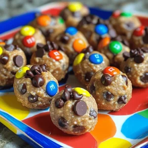 - 1 cup rolled oats - 1/2 cup creamy peanut butter - 1/3 cup honey or maple syrup - 1/4 cup mini chocolate chips - 1/4 cup M&M's or colorful chocolate candies - 1/4 cup ground flaxseed - 1/2 teaspoon vanilla extract - A pinch of sea salt The ingredients for No Bake Monster Cookie Energy Bites are simple and easy to find. Each one plays a key role in flavor and texture. These energy bites are not just tasty; they pack a punch of nutrition. Each bite has about 100 calories. The breakdown is around 3 grams of protein, 4 grams of fat, and 15 grams of carbs. They give you energy without the sugar crash. When selecting oats, use rolled oats. They give the best texture. Instant oats can make the bites too mushy. For peanut butter, choose a creamy type. Natural peanut butter is best. Check for added sugars or oils. A clean peanut butter will keep your bites healthy and tasty. For the full recipe, check the earlier section. Make these energy bites today! Mixing dry ingredients Start by gathering your dry ingredients. In a large mixing bowl, combine: - 1 cup rolled oats - 1/4 cup ground flaxseed - A pinch of sea salt Mix these ingredients well. This step ensures that the oats and flaxseed blend evenly. Preparing wet ingredients Next, grab another bowl. Whisk together: - 1/2 cup creamy peanut butter - 1/3 cup honey or maple syrup - 1/2 teaspoon vanilla extract Mix these until smooth. It should look creamy and well combined. Mixing wet and dry ingredients together Now, pour the wet mixture over the dry ingredients. Stir them together until fully combined. You want every bit of dry mix to absorb the wet ingredients. Incorporating chocolate chips and M&M's Once combined, gently fold in: - 1/4 cup mini chocolate chips - 1/4 cup M&M's or colorful chocolate candies Mix until you see the chocolate evenly spread throughout. Tips for shaping the bites Take a tablespoon-sized portion of the mixture. Roll it into a ball using your hands. If it’s too sticky, wet your hands with a little water. This will help shape the bites easier. How to store before refrigeration Place the rolled energy bites on a parchment-lined baking sheet or plate. This prevents them from sticking. You can then refrigerate them for at least 30 minutes. This cooling time helps them firm up. Enjoy making these No Bake Monster Cookie Energy Bites! For the complete recipe, check the Full Recipe section. To keep your energy bites from being too sticky, use cooled hands. Wet your hands with water before rolling. This simple trick makes it easier to form perfect balls. You can also adjust the recipe. If your mixture feels too wet, add more oats or flaxseed. If it's too dry, mix in a bit more peanut butter or syrup. Finding the right texture is key to a great bite. For gatherings, serve your energy bites in a bright bowl. A colorful platter adds fun and cheer. You might even sprinkle extra chocolate chips or M&M's on top for flair. These bites pair well with milk, coffee, or fruit juice. They make a great snack for kids and adults alike. If you want a nut-free option, use sunflower seed butter instead of peanut butter. It has a nice flavor and works well in this recipe. For sweeteners, try agave syrup or maple syrup if you prefer. Each sweetener brings a unique taste, so feel free to experiment. Using different options can lead to delicious results! You can find the Full Recipe for more details and steps on making these tasty bites. {{image_2}} You can change up the flavor of your energy bites easily. Try using different nut butters, like almond or cashew. This adds a unique taste. You can also mix in spices like cinnamon for warmth. Just a pinch can change the whole bite. Mix-ins are fun and flexible. Add dried fruits like raisins or cranberries for sweetness. You can also toss in seeds like chia or pumpkin for crunch. For chocolate lovers, use dark or white chocolate chips instead of mini ones. Each choice gives a new twist to the bites. Want to make these bites gluten-free? Use certified gluten-free oats. This small change makes them safe for those with gluten issues. If you're vegan, swap honey with maple syrup. You can also choose a nut butter that fits your diet. These simple swaps keep everyone happy. For the full recipe, check the details above. Enjoy crafting your energy bites! To keep your energy bites fresh, use an airtight container. A glass jar or a plastic food storage container works well. Store them in the fridge for the best taste and texture. They will stay fresh for up to one week. If you see them getting too soft, just pop them back in the fridge. You can freeze energy bites for longer storage. Place them in a single layer on a baking sheet. Freeze for about one hour. After they are firm, transfer them to a freezer-safe bag or container. They can last up to three months in the freezer. When you want to enjoy them, take out the bites and let them thaw in the fridge. This helps keep their flavor and texture. You can also eat them straight from the freezer if you like a chill! For more detailed steps, check the Full Recipe. No bake energy bites can last about one week in the fridge. Store them in an airtight container to keep them fresh. For longer storage, you can freeze them. They will stay tasty for up to three months in the freezer. Just remember to thaw them in the fridge before eating. Yes, you can easily make these energy bites nut-free. Use sun butter or soy nut butter instead of peanut butter. These options taste great and keep the bites creamy. Always check for allergies when serving to others. You can customize the flavors in many fun ways. Try adding different nut butters, like almond or cashew. You can also mix in spices like cinnamon or cocoa powder. Use dark chocolate chips instead of mini ones for a richer taste. Get creative with your favorite add-ins! These energy bites are best no-bake, but you can bake them if you want. Baking will change the texture, making them more like cookies. Bake at 350°F for about 10 minutes. Keep an eye on them to avoid burning. Enjoy your unique twist on the classic recipe! For the full recipe, check out the details above. No Bake Monster Cookie Energy Bites are easy to make and enjoy. We covered the best ingredients, like oats, peanut butter, and honey. You learned step-by-step instructions for mixing and rolling the bites. Tips helped ensure they turn out perfect every time. Feel free to try different flavors and customizations. Store them well so you have tasty snacks on hand. Now, you can enjoy a fun and healthy treat anytime!