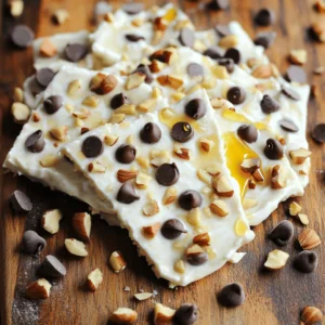 To make Cookie Dough Greek Yogurt Bark, you will need these key ingredients: - 2 cups plain Greek yogurt - ¼ cup honey or maple syrup - 1 teaspoon vanilla extract - ½ cup mini chocolate chips - ¼ cup almond flour (or finely ground oats) - ¼ cup chopped nuts (e.g., walnuts or pecans) - Pinch of sea salt These ingredients work together to create a creamy and tasty treat. The Greek yogurt gives the bark its smooth texture and protein punch. The honey or maple syrup adds just the right amount of sweetness. If you need alternatives, here are some ideas: - For Greek yogurt, use regular yogurt or a dairy-free option like coconut yogurt. - If you want a low-calorie sweetener, try stevia or agave syrup. These substitutes can help you fit your needs without losing flavor. To make your bark even more fun, consider these add-ins: - Dried fruit like cranberries or raisins for sweetness. - Shredded coconut for a tropical twist. - Different nuts like almonds or pecans for added crunch. These extras can make your bark unique and tasty. Feel free to mix and match based on what you love! To start, gather your ingredients. You need 2 cups of plain Greek yogurt, ¼ cup of honey or maple syrup, and 1 teaspoon of vanilla extract. In a mixing bowl, combine the Greek yogurt, honey, and vanilla. Stir until smooth. Next, add ¼ cup of almond flour and a pinch of sea salt. Mix until combined. This step adds texture and flavor. Finally, fold in ½ cup of mini chocolate chips and ¼ cup of chopped nuts. These add a nice crunch and extra flavor. Now it’s time to spread the mixture. Line a baking sheet with parchment paper. Pour the yogurt mixture onto the sheet. Use a spatula to spread it into an even layer, about ½ inch thick. For extra taste, sprinkle some more chocolate chips and nuts on top. Press them lightly into the mixture. Place the baking sheet in the freezer. Freeze for about 2-3 hours or until the bark is firm. This freezing makes it easy to break into pieces later. Once the bark is frozen, take it out of the freezer. Remove the parchment paper carefully. You can break the bark into pieces or cut it into squares. Use a sharp knife for clean cuts. Store the pieces in an airtight container. Keep them in the freezer until you are ready to enjoy this treat. This helps keep the bark fresh and tasty. To get that creamy texture, start with thick Greek yogurt. It needs to be plain and full-fat. This gives the bark a rich taste. Mixing in almond flour helps create a nice bite. Make sure to blend it well with the yogurt. The mixture should feel smooth and thick. If it is too runny, the bark may not hold together. Use a spatula to spread it evenly on the baking sheet. This helps it freeze uniformly. You can easily change the flavors to fit your taste. Try adding a bit of cinnamon for warmth. You can also mix in other extracts like almond or hazelnut. For a fruity twist, add chopped dried fruits like cranberries or apricots. You can swap out the mini chocolate chips for dark chocolate or even white chocolate. If you want a nutty flavor, try using different nuts like pecans or hazelnuts. Feel free to be creative! A big mistake is not measuring the ingredients. Always use the right amounts for the best taste. Another mistake is not allowing enough freezing time. If the bark is not frozen long enough, it will be too soft. Avoid overmixing the yogurt mixture too. This can make it watery and thin. Lastly, remember to line your baking sheet with parchment paper. This makes it easier to remove the bark once it is frozen. {{image_2}} You can make a tasty, dairy-free version of this treat. Use coconut yogurt instead of Greek yogurt. It has a creamy texture and a subtle flavor. For sweetener, try agave syrup or maple syrup. These swaps keep it delicious without dairy. Don't forget to check labels to ensure your yogurt is dairy-free. Get creative with flavors! You can swap the vanilla extract for almond or hazelnut extract. This change adds a nutty twist. Want a fruity kick? Mix in some mashed banana or pureed strawberries. You can also try adding spices, like cinnamon or nutmeg. Each change gives your bark a unique taste. You can adjust your bark for the seasons. In fall, add pumpkin spice and chopped apples. For winter, mix in peppermint extract and crushed candy canes. In summer, try fresh berries and a hint of lemon zest. Each season brings fresh ideas to your bark, making it fun to enjoy year-round. To keep your Cookie Dough Greek Yogurt Bark fresh, store it in an airtight container. Make sure the container is freezer-safe. This will help prevent freezer burn. If you have leftover pieces, you can layer them with parchment paper. This way, they won’t stick together. When you're ready to enjoy a piece, take it out of the freezer. Let it sit at room temperature for about 5 minutes. This helps to soften it just enough for easy munching. When stored properly, your bark can last up to two months in the freezer. This means you can make a big batch and enjoy it later. Just remember: the fresher the bark, the better it tastes. I recommend eating it within a month for the best flavor and texture. Cookie Dough Greek Yogurt Bark is great on its own. But you can also pair it with fresh fruit like strawberries or bananas. For a fun twist, serve it with a drizzle of chocolate sauce. It makes a great snack for kids and adults alike. You can even break it into smaller pieces and add it to a smoothie for a sweet treat. Remember, the possibilities are endless! You can use other types of yogurt, but Greek yogurt works best. It gives a thick texture and creamy taste. If you use regular yogurt, the bark may not hold its shape as well. You can try dairy-free options too, but check if they are thick enough. To make this bark vegan, use dairy-free yogurt. Coconut yogurt or almond yogurt are great choices. Substitute honey with maple syrup or agave nectar. This way, you keep the sweetness without using animal products. Yes, you can use alternative sweeteners. Stevia, agave syrup, or monk fruit sweetener work well. Just remember to adjust the amount based on sweetness level. This keeps the bark tasty without adding extra sugar. Absolutely! Adding protein powder is a great idea. It boosts nutrition and keeps you full longer. Mix in a scoop of your favorite flavor when combining the yogurt. Make sure to blend well for even flavor throughout the bark. This blog post covered how to make delicious cookie dough Greek yogurt bark. We discussed key ingredients, substitutes, and fun add-ins that boost flavor and crunch. I detailed preparation and freezing steps, plus tips for perfect texture and common mistakes to avoid. We explored dairy-free options, unique flavors, and how to store it well. Remember, you can customize this bark to fit your taste. Enjoy creating this treat and share it with friends and family!