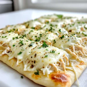 To make Chicken Alfredo Flatbread, gather these items: - 2 large flatbreads or naan - 1 cup cooked chicken breast, shredded - 1 cup Alfredo sauce - 1 cup shredded mozzarella cheese - ½ cup grated Parmesan cheese - ½ teaspoon garlic powder - ½ teaspoon Italian seasoning - Salt and pepper to taste - Fresh parsley, chopped (for garnish) You can swap flatbreads for pita or tortillas. They will still taste great. For the chicken, use rotisserie chicken for quick prep. If you want less fat, use low-fat Alfredo sauce. You can also use vegan cheese if you're avoiding dairy. For seasoning, fresh garlic can replace garlic powder. To make this dish, you need a few tools: - Baking sheet - Parchment paper - Mixing bowl - Spoon for mixing - Knife for slicing - Oven for baking These tools help you create a tasty Chicken Alfredo Flatbread with ease. Start by preheating your oven to 400°F (200°C). This helps the flatbreads get crispy. Line a baking sheet with parchment paper. This makes cleanup easy later on. Place the flatbreads or naan on the sheet. Make sure they are spread out well. In a medium bowl, combine the shredded chicken and Alfredo sauce. Add garlic powder, Italian seasoning, salt, and pepper. Mix this well until the chicken is coated nicely. This step is key for flavor. The sauce makes the chicken creamy and rich. Now, spread the chicken mixture evenly over each flatbread. Don’t be shy; use it all! Next, sprinkle the shredded mozzarella and grated Parmesan on top. This will create a cheesy crust. Bake your flatbreads in the oven for about 12-15 minutes. Look for the cheese to melt and bubble. You want the edges golden brown. Once done, take them out and let them cool for a minute. Slice and serve! Garnish with chopped parsley for a fresh touch. To get that gooey, melty cheese, use fresh mozzarella. Fresh cheese melts better than old cheese. Mix mozzarella with Parmesan for extra flavor. Use the right amount; too much can make it greasy. Bake until it bubbles and turns golden brown. This takes about 12 to 15 minutes at 400°F. Soggy flatbread can ruin your meal. To avoid this, bake your flatbread first for 3-5 minutes. This helps it stay crispy. Spread your chicken mixture on hot flatbreads. Use less sauce or drain excess liquid from the chicken. This keeps your flatbread crunchy and delicious. Chicken Alfredo Flatbread pairs well with many sides. Try a fresh salad for a light touch. Garlic bread is another tasty choice. You can also serve it with marinara sauce for dipping. A nice glass of white wine matches well, too. Enjoy your meal with family and friends! {{image_2}} To make a vegetarian version, skip the chicken. Use cooked mushrooms or spinach instead. You can also add bell peppers or artichokes. Just mix these veggies with the Alfredo sauce. This will keep the creamy taste while adding fresh flavors. Want some heat? Add red pepper flakes to the Alfredo sauce. You can also use spicy chicken. Mix in some jalapeños or sriracha for a real kick. This adds a nice contrast to the creamy sauce and makes the dish exciting. You can switch the Alfredo sauce for pesto or marinara. This gives a fresh twist to the flatbread. Try a garlic or cheese sauce for a rich flavor. Each sauce brings its own unique taste, keeping your meals fun and varied. To keep your Chicken Alfredo Flatbread fresh, store it in an airtight container. It can last in the fridge for about 3 to 4 days. Make sure it cools down before you seal it. This helps prevent sogginess and keeps the flavors intact. If you want to save some for later, freezing is a great option. Wrap each flatbread tightly in plastic wrap, then place them in a freezer bag. This keeps out air and freezer burn. You can freeze them for up to 2 months. When you’re ready to eat, just thaw in the fridge overnight. Reheating is simple! Preheat your oven to 350°F (175°C). Place the flatbread on a baking sheet. Heat for about 10 to 15 minutes or until warm. You can also use a microwave, but this may make the flatbread soggy. For the best taste, I recommend the oven method. Enjoy every bite! Yes, you can use store-bought Alfredo sauce. It saves time and still tastes great. Look for a brand with simple ingredients. This makes it easy to enjoy Chicken Alfredo Flatbread without stress. If you want more flavor, try adding garlic or herbs to the sauce. You can add many tasty items to boost flavor. Here are some ideas: - Spinach: Fresh or cooked spinach adds color and nutrition. - Mushrooms: Sautéed mushrooms give an earthy taste. - Sun-dried tomatoes: These offer a sweet and tangy kick. - Buffalo sauce: For a spicy twist, drizzle some buffalo sauce on top. - Extra herbs: Fresh basil or oregano can brighten the dish. Feel free to mix and match these to suit your taste! Chicken Alfredo Flatbread lasts for about 3-4 days in the fridge. Store it in an airtight container to keep it fresh. If you want it to last longer, you can freeze it. Just wrap the flatbreads well in plastic wrap and foil. They can stay good for up to 2 months in the freezer. You learned how to make Chicken Alfredo Flatbread from start to finish. We covered the right ingredients, step-by-step methods, and handy tips. You can experiment with fun variations and store any extras well. Remember, cooking is all about trying new things and having fun. Enjoy your dish, share it with friends, and get creative. Trust me; you’ll love every bite!