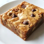 To make your blondies, you need simple yet tasty items: - 1 cup unsalted butter - 1 cup packed brown sugar - ½ cup granulated sugar - 2 large eggs - 1 teaspoon vanilla extract - 2 cups all-purpose flour - 1 teaspoon baking powder - ½ teaspoon baking soda - ¼ teaspoon salt - 1 cup chocolate chips (semisweet or milk) - ½ cup chopped nuts (optional, like walnuts or pecans) Each ingredient plays a key role. The butter gives rich flavor. The sugars add sweetness and texture. Eggs bind everything together. Flour gives structure. Baking powder and baking soda help them rise. You can take your blondies up a notch with some fun add-ins! Here are some ideas: - ½ cup of shredded coconut for a tropical flair - ½ cup of dried fruit like cranberries or apricots for a chewy bite - A sprinkle of sea salt on top to enhance sweet flavors These add-ins let you customize your blondies. You can make each batch unique and exciting. If you need to swap some items, here are great options: - Use coconut oil instead of butter for a dairy-free treat - Replace all-purpose flour with oat flour for a gluten-free option - Try maple syrup in place of granulated sugar for a deeper flavor These substitutions will still give you delicious blondies. You can enjoy them no matter your dietary needs. {{ingredient_image_1}} Start by preheating your oven to 350°F (175°C). Line a 9x13 inch baking pan with parchment paper. Leave some paper over the sides to help lift out the blondies later. In a medium saucepan, melt one cup of unsalted butter over medium heat. Stir it often. Cook until the butter turns a golden brown and smells nutty. This takes about 5 to 7 minutes. Be careful not to burn it. After that, pour the browned butter into a mixing bowl and let it cool for a few minutes. Once cooled, mix in one cup of packed brown sugar and half a cup of granulated sugar. Stir until the mix is smooth. Add two large eggs, one at a time, mixing well after each egg. Next, stir in one teaspoon of vanilla extract. In another bowl, whisk together two cups of all-purpose flour, one teaspoon of baking powder, half a teaspoon of baking soda, and a quarter teaspoon of salt. Gradually add this dry mix to the wet ingredients, stirring until just combined. Be careful not to overmix. Finally, gently fold in one cup of chocolate chips and half a cup of chopped nuts, if you like. Now, pour the batter into your prepared baking pan. Spread it out evenly. Place the pan in the oven and bake for 20 to 25 minutes. The edges should look lightly golden. To check if they are done, insert a toothpick in the center. If it comes out with a few moist crumbs, your blondies are ready! After baking, let the blondies cool in the pan for about 10 minutes. Use the parchment paper to lift them out. Move them to a wire rack to cool completely. Once cool, cut them into squares. Enjoy your chewy brown butter blondies! To get that chewy texture, don’t overmix your batter. Mix just until the flour disappears. Adding brown sugar helps keep your blondies moist and chewy. The brown butter also adds richness that boosts the chewiness. Finally, let them cool before cutting. This helps them set and hold their shape. Brown butter is key to making these blondies shine. Melt your butter slowly over medium heat. Keep stirring until it turns a beautiful golden brown. You’ll know it’s done when it smells nutty. This process adds a deep, rich flavor that makes your blondies special. Remember to let it cool before mixing it with sugar and eggs. One common mistake is not measuring ingredients correctly. Use a kitchen scale for accuracy if you can. Another mistake is opening the oven door too soon. This can cause the blondies to sink. Always check for doneness with a toothpick. It should come out with a few moist crumbs, not wet batter. Avoiding these mistakes will help you bake perfect blondies every time. Pro Tips Use Fresh Ingredients: Always use fresh eggs and quality chocolate chips for the best flavor and texture in your blondies. Don't Overmix: When combining the wet and dry ingredients, mix just until combined to maintain a chewy texture. Cool Before Cutting: Allow the blondies to cool completely before cutting to ensure clean edges and prevent them from falling apart. Experiment with Mix-ins: Feel free to add your favorite mix-ins like dried fruit or different types of nuts for a unique twist on the classic blondie. {{image_2}} If you want nut-free blondies, simply skip the nuts. You can still enjoy a chewy texture and rich flavor. The chocolate chips will add enough sweetness. If you like, add a bit more flour to keep the texture nice. This way, those with nut allergies can enjoy this treat too! You can change the flavor of your blondies easily. Adding spices like cinnamon or nutmeg gives a warm taste. A teaspoon of almond extract can add a nice twist. Want a tropical touch? Add some shredded coconut. These small changes can create a whole new dessert experience. Taste buds will thank you! Using different types of chocolate is simple. If you love dark chocolate, swap in dark chocolate chips. They will give a richer flavor. For a sweeter treat, use white chocolate chips. You can even mix them for a fun blend. Each type of chocolate brings its own magic to these blondies. Enjoy experimenting! To keep your chewy brown butter blondies fresh, store them in an airtight container. This helps keep them soft and chewy. Place parchment paper between layers to prevent sticking. Store them at room temperature for up to five days. If you want them to last longer, the fridge can work too. Just know that cold blondies may lose some chewiness. Freezing blondies is easy and a smart choice. Start by letting them cool completely. Once cool, cut them into squares. Wrap each square in plastic wrap. Then, place the wrapped blondies in a freezer bag. They can stay in the freezer for up to three months. When you’re ready to enjoy, simply take one out and let it thaw at room temperature. If you want to warm up your blondies, the oven is best. Preheat your oven to 350°F (175°C). Place the blondies on a baking sheet for about 5-10 minutes. This warms them and brings back their chewy texture. You can also use a microwave. Heat them for about 10-15 seconds. Be careful not to overheat; you want them warm, not hot. Enjoy every bite! Blondies and brownies look alike, but they taste very different. Blondies use brown sugar, while brownies use cocoa powder. That gives blondies a sweet, butterscotch flavor. Brownies have richer chocolate flavor. The texture is also different. Blondies are chewy and soft, while brownies can be fudgy or cake-like. To check if your blondies are done, look at the edges. They should be lightly golden. Insert a toothpick in the center. If it comes out with a few moist crumbs, they are ready. If it comes out wet with batter, bake them a bit longer. This usually takes about 20 to 25 minutes. You can use margarine, but it will change the flavor a bit. Butter gives blondies a rich taste. Margarine may not brown like butter, which adds a nutty flavor. If you need to use margarine, choose one that has a higher fat content for better results. In this post, I covered key ingredients for chewy brown butter blondies and helpful tips for baking. You learned how to prepare the batter, bake your blondies, and cool them properly. I shared storage tips and answered common questions about blondies. Brown butter adds a rich taste you will love. Baking is fun, so don’t be afraid to try new flavors. Enjoy your blondies and share with friends.