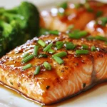 To make this tasty maple glazed salmon, you need: - 4 salmon fillets (6 ounces each) - ¼ cup pure maple syrup - 2 tablespoons soy sauce (or tamari for gluten-free) - 1 tablespoon Dijon mustard - 1 tablespoon fresh ginger, grated - 2 cloves garlic, minced - Salt and pepper to taste - 1 tablespoon olive oil - Fresh chives, chopped (for garnish) These ingredients blend to create a sweet and savory glaze that makes the salmon shine. You can add a few ingredients to boost the flavor: - Sesame oil for a nutty taste - Lemon juice for a zesty kick - Chili flakes for some heat - Green onions for a fresh touch Feel free to experiment with these options. They can change the dish in exciting ways. If you have allergies or dietary needs, here are some swaps: - For a dairy-free option, ensure your mustard is dairy-free. - If you dislike soy sauce, try coconut aminos. - Use maple syrup alternatives like honey or agave, but note that flavors will change. Always check labels to ensure your substitutions work for your diet. This way, everyone can enjoy this dish! {{ingredient_image_1}} To make the marinade, grab a small bowl. Add ¼ cup of pure maple syrup. Next, pour in 2 tablespoons of soy sauce. Then, add 1 tablespoon of Dijon mustard. Grate 1 tablespoon of fresh ginger and add it too. Finally, mince 2 cloves of garlic and toss them in. Mix everything well and sprinkle a pinch of salt and pepper. Your marinade is ready! Now, take your salmon fillets and place them in a shallow dish. Pour the marinade over the salmon. Make sure every piece is coated. Cover the dish and put it in the fridge. Let it marinate for at least 30 minutes. You can leave it for up to 2 hours for more flavor. Preheat your oven to 400°F (200°C). After marinating, take the salmon out. Reserve the marinade for later. Pat the fillets dry with a paper towel. Lightly season them with salt and pepper. In a large oven-safe skillet, heat 1 tablespoon of olive oil over medium-high heat. Once hot, place the salmon skin-side down. Sear it for about 3-4 minutes until the skin is crispy. Carefully flip the salmon and pour the reserved marinade over it. Transfer the skillet to your preheated oven. Bake for 10-12 minutes. The salmon should flake easily with a fork when done. Let it rest for a couple of minutes before serving. Enjoy your tasty maple glazed salmon! To get that perfect glaze on your salmon, follow these tips: - Use pure maple syrup for real flavor. - Make sure to marinate the salmon for at least 30 minutes. This allows the flavors to soak in. - Reserve some marinade to pour over the salmon while it bakes. This adds a rich taste and helps create a nice glaze. - For a shiny finish, broil the salmon for a minute or two after baking. Just watch it closely! You can cook salmon in several tasty ways: - Pan-searing gives you a nice crispy skin. Start it on the stove and finish it in the oven. - Baking is easy and lets the flavors blend well. Use the oven at 400°F (200°C) for best results. - Grilling adds a smoky flavor. Just make sure to use a grill mat to prevent sticking. - Broiling cooks the salmon quickly and gives a nice char. Just remember to keep an eye on it. To ensure your salmon is just right, follow these temperature tips: - Cook salmon until it reaches an internal temperature of 145°F (63°C). This keeps it safe to eat. - For medium-rare, aim for 125°F (52°C). It will be more tender and juicy. - Use a meat thermometer for accurate readings. This helps you avoid overcooking and keeps the salmon moist. Pro Tips Marinating Time: For the best flavor, marinate the salmon for at least 1 hour. If you have the time, marinating overnight enhances the taste even more. Crispy Skin: Ensure your skillet is hot before adding the salmon skin-side down to achieve that perfect crispy texture. Check Doneness: Use a fork to gently flake the salmon; it should easily separate at the thickest part. The internal temperature should be 145°F for perfect doneness. Serving Suggestion: Pair with a side of quinoa salad or roasted vegetables to complement the sweet and savory flavors of the salmon. {{image_2}} You can add a fresh twist with citrus. Use orange or lemon juice in the marinade. Just swap out one tablespoon of maple syrup for two tablespoons of citrus juice. The bright flavor pairs well with the salmon. This adds a zesty kick and balances the sweetness. You can also add citrus zest for extra aroma. For those who like heat, try adding spice. Mix in a teaspoon of red pepper flakes into the marinade. This gives the dish a nice, warm bite. You can also use sriracha or hot sauce for a stronger flavor. The sweet and spicy combination is a real crowd-pleaser. Herbs can elevate your salmon even more. You can add fresh dill, parsley, or basil to the marinade. Just chop them finely and mix them in. This adds a fresh, green note that brightens the dish. Try using thyme for a subtle earthiness. Each herb brings its own unique flavor, making it a delightful twist. To keep leftover salmon fresh, place it in an airtight container. If you have a cover, seal the container tightly. Store it in the fridge for up to three days. Make sure the salmon is cool before sealing. This helps prevent bacteria growth. When you're ready to eat the leftover salmon, I suggest reheating it gently. Preheat your oven to 350°F (175°C). Place the salmon on a baking sheet lined with foil. Cover it with foil to keep it moist. Heat for about 10 to 15 minutes. You can also use a microwave. Heat it in 30-second bursts. Check to avoid overcooking. If you want to save salmon for later, freezing is a great option. First, let the salmon cool completely. Wrap each fillet tightly in plastic wrap. Then place the wrapped salmon in a freezer-safe bag. Remove as much air as possible. You can freeze it for up to three months. When you’re ready to eat, thaw it overnight in the fridge before reheating. The best type of salmon for this recipe is wild-caught salmon. Wild salmon has a great flavor and firm texture. You can also use farmed salmon, which is more common and often less expensive. Look for salmon fillets that are bright in color and smell fresh. Some popular types include sockeye and king salmon. They hold up well to the glaze and cooking methods. Yes, you can make this recipe ahead of time. Marinating the salmon can boost the flavor. You can prepare the marinade up to a day in advance. Just keep it in the fridge until you’re ready to marinate the salmon. Marinate the salmon for at least 30 minutes, but it’s fine to go up to 2 hours. If you're short on time, you can still get great taste with a shorter marinating time. There are many tasty side dishes to pair with maple glazed salmon. Here are some ideas: - Steamed broccoli - Roasted sweet potatoes - Quinoa salad - Garlic mashed potatoes - Grilled asparagus - Brown rice These sides add great color and nutrients to your plate. They also help balance the sweet flavor of the salmon. In this blog post, we covered how to make maple glazed salmon. We explored main and optional ingredients, cooking steps, and helpful tips. You learned about tasty variations and how to store leftovers effectively. Maple glazed salmon is versatile and delicious. Feel free to tweak the recipe to fit your tastes. Remember, cooking is fun, and you can enjoy your meals even more with a personal touch. Happy cooking!