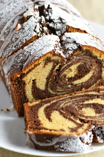 - 1 cup unsalted butter, softened - 1 ½ cups granulated sugar - 4 large eggs - 2 cups all-purpose flour - 1 teaspoon baking powder - ½ teaspoon salt - 1/2 cup brewed coffee, cooled - 1/2 cup unsweetened cocoa powder - 1 teaspoon vanilla extract - 1 teaspoon espresso powder - 1 cup powdered sugar (for glaze) - 2 tablespoons milk (for glaze) For this cake, precise measurements matter. Use a kitchen scale for best results. If you need to swap some ingredients, here are ideas: - Unsalted butter can be replaced with a plant-based butter. - Granulated sugar can switch to coconut sugar for a hint of caramel. - All-purpose flour can be substituted with a gluten-free blend. - Brewed coffee can be replaced with strong brewed tea for a different taste. Certain ingredients add depth to this cake. Espresso powder intensifies the coffee flavor. Use high-quality cocoa powder for a rich chocolate taste. Freshly brewed coffee makes a notable difference, too. These ingredients create a unique blend of mocha and chocolate. They keep the cake moist and flavorful, making each bite a delight. {{ingredient_image_1}} Start by preheating your oven to 350°F (175°C). Grease a 9x5-inch loaf pan to keep the cake from sticking. In a large bowl, cream together 1 cup of softened unsalted butter and 1 ½ cups of granulated sugar. Mix until it looks light and fluffy. Next, add 4 large eggs one by one. Make sure to mix well after each egg. In another bowl, whisk together 2 cups of all-purpose flour, 1 teaspoon of baking powder, and ½ teaspoon of salt. Gradually mix this dry blend into the butter mixture. Alternate adding the ½ cup of cooled brewed coffee. Keep mixing until everything is just combined. Now it’s time to divide the batter. Split it into two equal parts. In one half, stir in ½ cup of unsweetened cocoa powder, 1 teaspoon of espresso powder, and 1 teaspoon of vanilla extract. This chocolate mix will add rich flavor. To create the swirl, begin layering the batters in the loaf pan. Start with a spoonful of the vanilla batter, followed by a spoonful of the chocolate batter. Keep alternating until both batters are used up. Use a knife to gently swirl them together. This will give your cake a beautiful marbled look. Place the loaf pan in your preheated oven. Bake for 50 to 60 minutes. Check if it's done by inserting a toothpick into the center. It should come out clean. Once baked, let the cake cool in the pan for 10 minutes. After that, transfer it to a wire rack to cool completely. While the cake cools, prepare the glaze. In a bowl, whisk together 1 cup of powdered sugar and 2 tablespoons of milk until smooth. Drizzle this over your cooled pound cake before serving. Enjoy your delicious mocha swirl pound cake! When making mocha swirl pound cake, avoid these mistakes for the best results: - Not softening the butter: Use softened butter for a fluffy mix. Cold butter won't blend well. - Overmixing the batter: Mix just until combined. Overmixing can make the cake dense. - Skipping the cooling step: Let the cake cool in the pan. This helps it firm up and makes it easier to remove. - Not checking your oven temperature: Use an oven thermometer to ensure accurate baking. An oven that is too hot or too cool can change your cake's texture. Creating beautiful swirls is fun and easy. Here’s how to do it: - Spoon batter alternately: Place a spoonful of vanilla batter, then a spoonful of chocolate batter. Repeat until the pan is full. - Use a knife gently: Take a butter knife and run it through the batter in a figure-eight motion. This creates a lovely marbled look. - Don’t over-swirl: Swirl just enough to mix the batters without losing the distinct layers. Too much swirling will blend the flavors completely. A glaze adds a sweet finish to your cake. Here are tips for a perfect glaze: - Use room temperature milk: This helps the glaze mix smoothly. Cold milk can make it lumpy. - Whisk well: Combine the powdered sugar and milk until there are no lumps. A smooth glaze looks better. - Drizzle over cooled cake: Let the cake cool completely before adding the glaze. Hot cake will melt the glaze, making it runny. - Add extra flavor: For a twist, mix in a bit of coffee or cocoa powder into the glaze. This enhances the mocha flavor and makes it even more special. Pro Tips Use Room Temperature Ingredients: Make sure your butter and eggs are at room temperature for a smoother batter and better texture. Don’t Overmix: When combining the batter, mix just until the ingredients are incorporated to avoid a dense cake. Check for Doneness: Insert a toothpick into the center of the cake; it should come out clean or with a few crumbs for perfect doneness. Let It Cool Completely: Allow the cake to cool completely before glazing to ensure the glaze sets properly. {{image_2}} You can change the flavor of your mocha swirl pound cake easily. Try using different extracts. Almond or hazelnut extracts add a unique twist. You can also swap out the brewed coffee for flavored coffee. This adds depth to the cake's taste. For a sweeter note, add a bit more sugar. Want a richer flavor? Use dark cocoa powder instead of regular cocoa. Each adjustment gives the cake a new life. Making a gluten-free mocha swirl pound cake is simple. Replace all-purpose flour with gluten-free all-purpose flour. This swap works well in most recipes. Just check that your baking powder is gluten-free. You may need to adjust the liquid slightly. Some gluten-free flours absorb more moisture. The cake will still taste amazing and be a hit! Adding nuts or chips can enhance the texture of your cake. Chopped walnuts or pecans add a nice crunch. Fold these in gently before baking. Chocolate chips work great too. They melt and create pockets of gooey chocolate. Use semi-sweet or dark chocolate chips for a richer flavor. These additions make each slice even more delightful. Store your mocha swirl pound cake in an airtight container. This keeps it fresh and moist. You can place it at room temperature for up to three days. If you want to keep it longer, the fridge is a good option. Just remember, cold air can dry it out. Wrap it well in plastic wrap or foil before putting it in the fridge. This way, it stays soft and tasty. To freeze the cake, first let it cool completely. Wrap it tightly in plastic wrap. Then, place the wrapped cake in a freezer bag. This prevents freezer burn and keeps the flavor. You can freeze it for up to three months. When you are ready to enjoy, thaw it in the fridge overnight. This helps it regain moisture and taste great. To reheat the mocha swirl pound cake, slice it first. You can use a microwave or an oven. For the microwave, warm it for about 15-20 seconds. Check it often to avoid overheating. For the oven, preheat it to 350°F (175°C). Place slices on a baking sheet and heat for 5-10 minutes. This warms the cake and brings back its soft texture. Enjoy with a drizzle of glaze or a cup of coffee! Yes, you can use any brewed coffee you like. Dark roast coffee adds a strong flavor. Light roast coffee gives a milder taste. You can also try flavored coffee. Vanilla or hazelnut coffee can make it unique and fun. Just make sure it’s brewed and cooled before adding to the batter. Mocha swirl pound cake lasts about four to five days at room temperature. Store it in an airtight container to keep it fresh. If you want it to last longer, you can freeze it. It stays good in the freezer for up to three months. Just wrap it tightly in plastic wrap. Mocha pairs well with many flavors. Here are some tasty options: - Peppermint for a minty twist. - Orange zest adds a bright citrus note. - Almond extract gives a nutty flavor. - Sea salt can enhance the sweet and rich coffee taste. Mix and match to find your favorite combo! This blog post covered all you need for a great mocha cake. We explored the key ingredients, including special ones for better flavor. I shared step-by-step instructions for batter, swirling, and baking. You learned tips to avoid common mistakes and make the best glaze. Variations let you change flavors or go gluten-free. Lastly, I shared storage tips to keep your cake fresh. Enjoy your baking, and make every slice delicious!